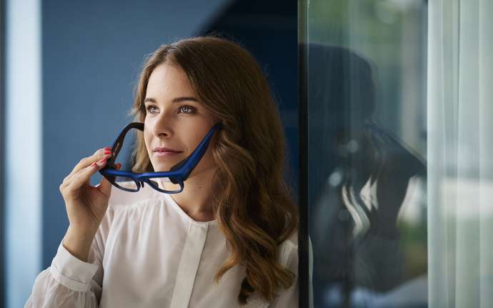 Female putting on a pair of augmented reality (AR) smart glasses