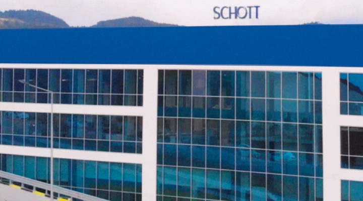 Modern industrial building with blue accents, large flat roof, and multiple loading docks, and adjacent warehouses.