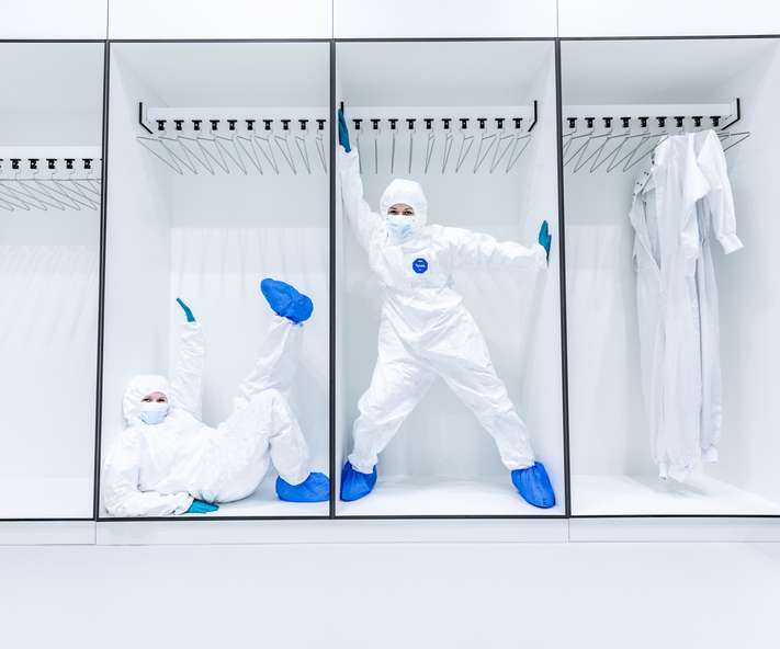 一名身穿洁净室服装的人走过实验室。