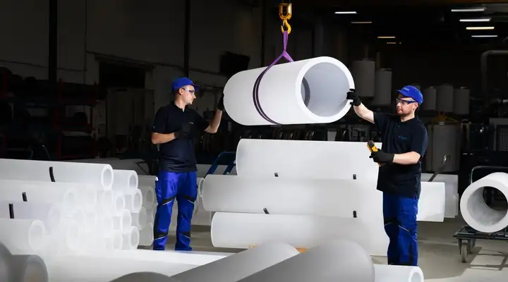 Two SCHOTT employees transport a large cylindrical quartz glass component