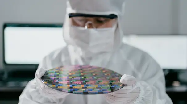 Chip engineer holding a glass wafer. 