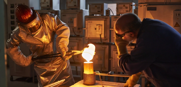 Gunther Paulus in fire protection gear in the melting laboratory with a colleague