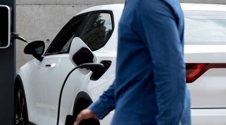 Person charging an electric car at a public charging station