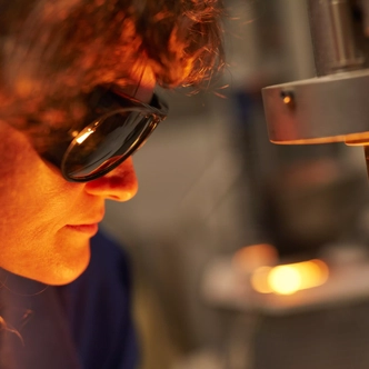SCHOTT employee monitors process in melting laboratory through safety goggles