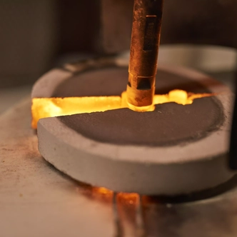 The melted glass is poured into a shallow container in the melting laboratory
