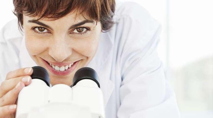 Person using a stereo microscope in a laboratory setting