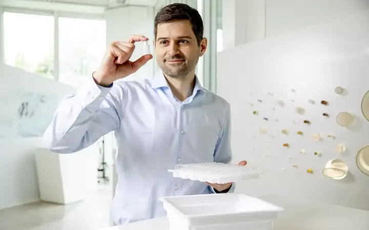 Man holds up pharmaceutical glass cartridge