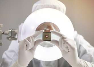 Scientist inspecting miniaturized glass-based semiconductor packaging