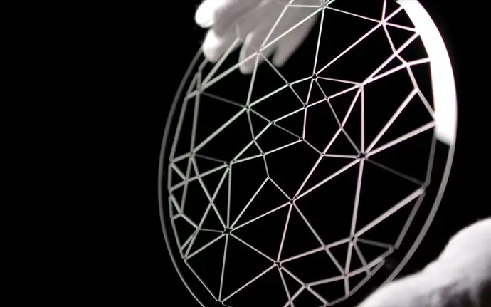  Gloved hands holding a patterned structured glass wafer made from SCHOTT FLEXINITY® 