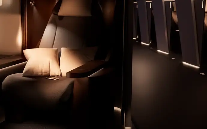 Aircraft seat with cushions and illuminated side panel next to a softly lit cabin aisle