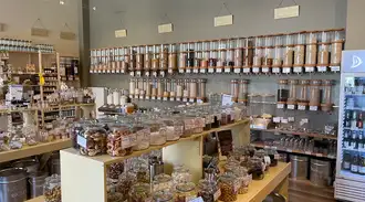   A hawos unpacked store with glass tubes and jars containing dry goods 