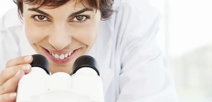 Person using a stereo microscope in a laboratory setting