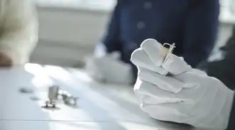 Technician holding a miniaturized hermetic component in gloved hands for inspection