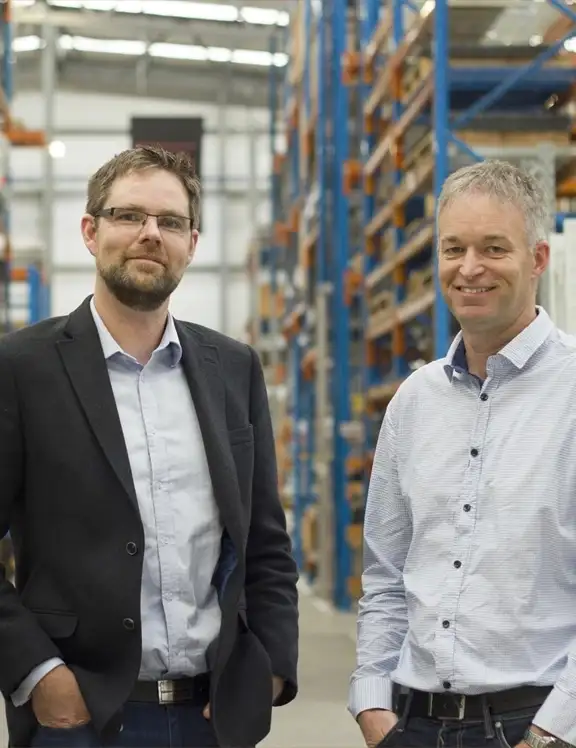 A group of men standing in a warehouse